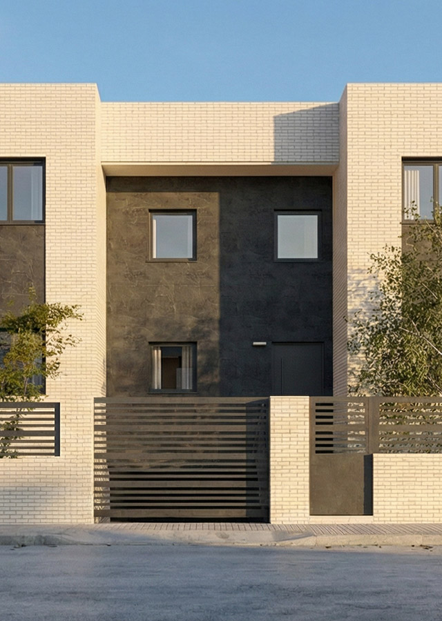 Fachada exterior de diseño moderno en chalet de Valdemoro. Combina ladrillo visto color claro con revestimiento central gris oscuro, carpintería de aluminio negro y valla perimetral de seguridad con diseño de lamas horizontales.